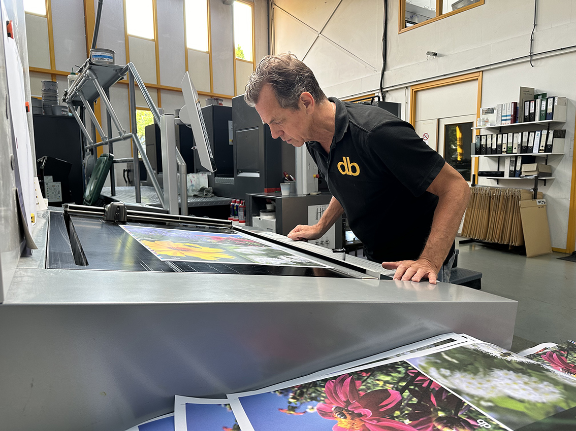 Man controleert afdrukkwaliteit in drukkerij.