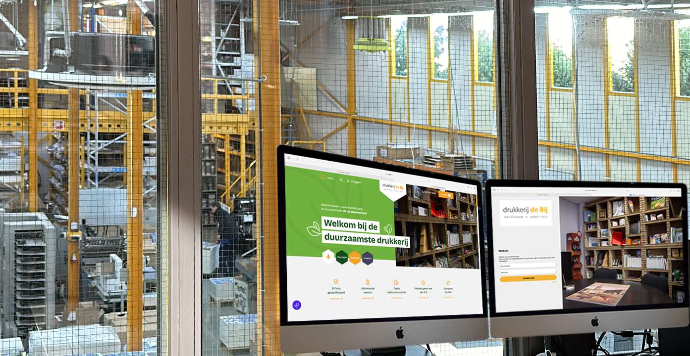 Drukkerij met computerschermen en bureau.