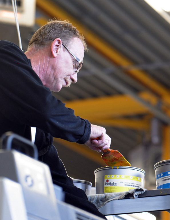 Persoon mengt verf in fabriekshal