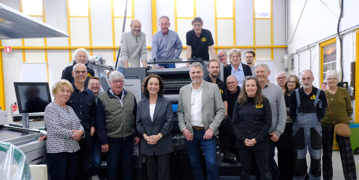 Groep mensen staat samen in een werkplaats.