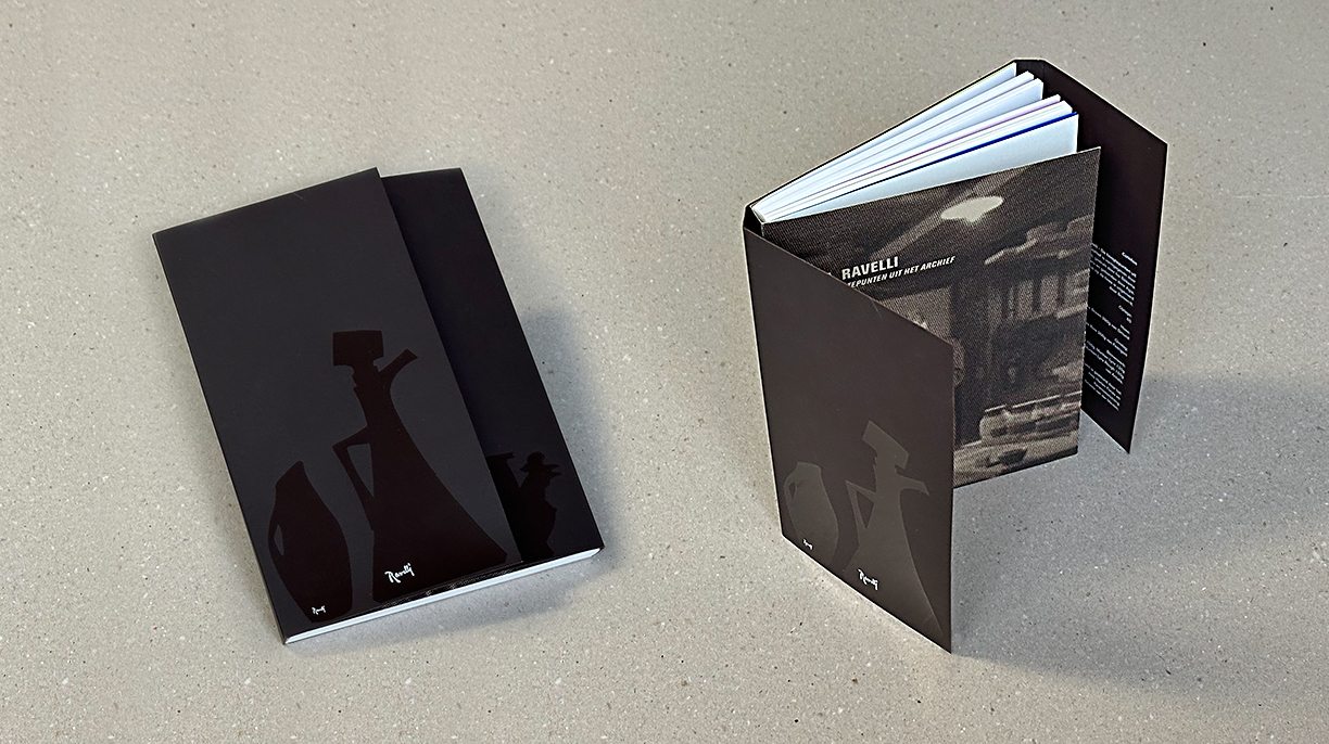 Twee zwarte boeken met silhouetdesigns, liggend en openstaand.